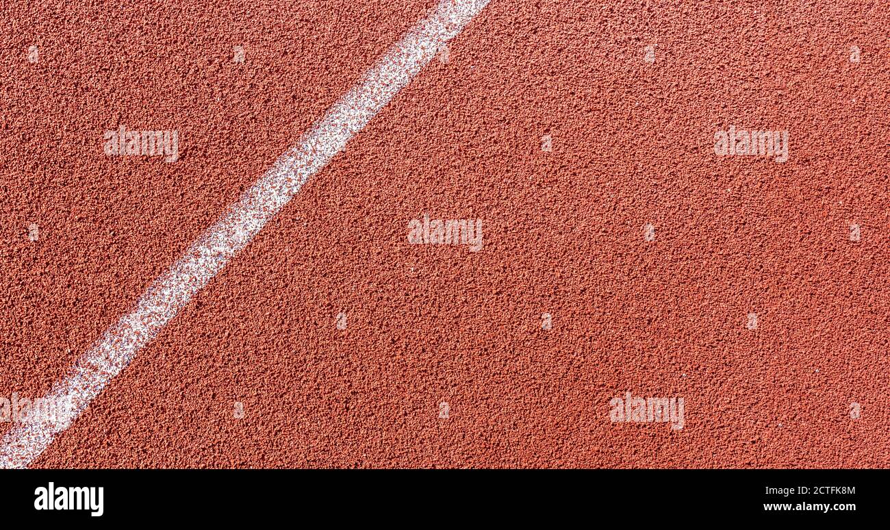 Linea dipinta di bianco sulla pista di terra in tartan in un campo sportivo e atletico. . Foto di alta qualità Foto Stock