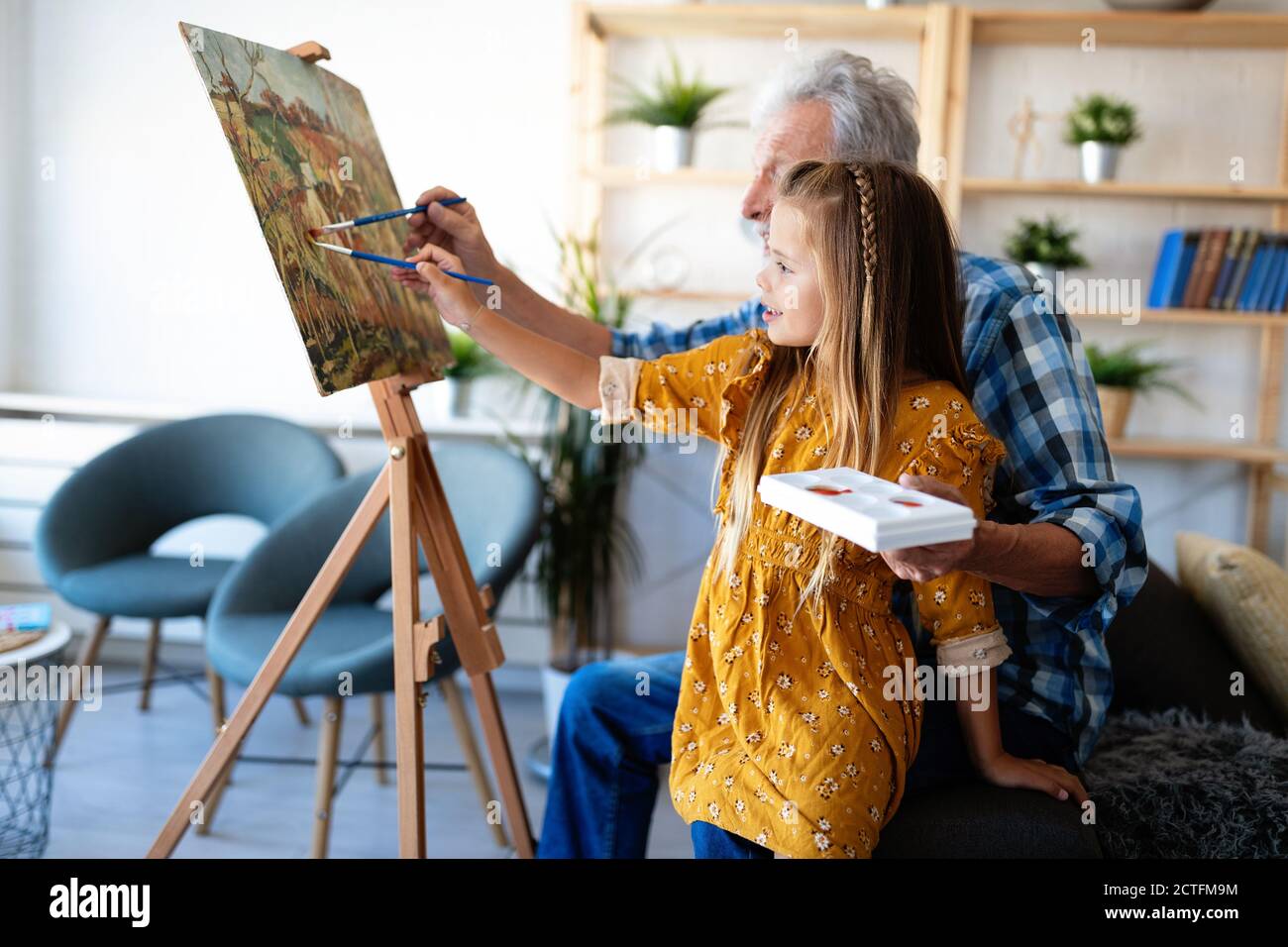 Senior uomo con bambino dipinto su tela. Nonno spendere tempo felice con il nipote. Foto Stock