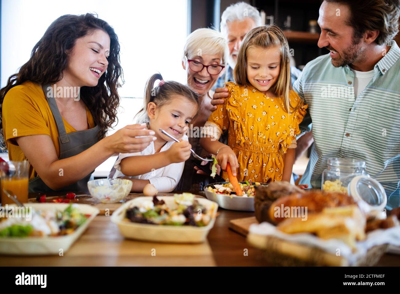 Famiglia allegra spendendo bene insieme durante la cottura in cucina Foto Stock