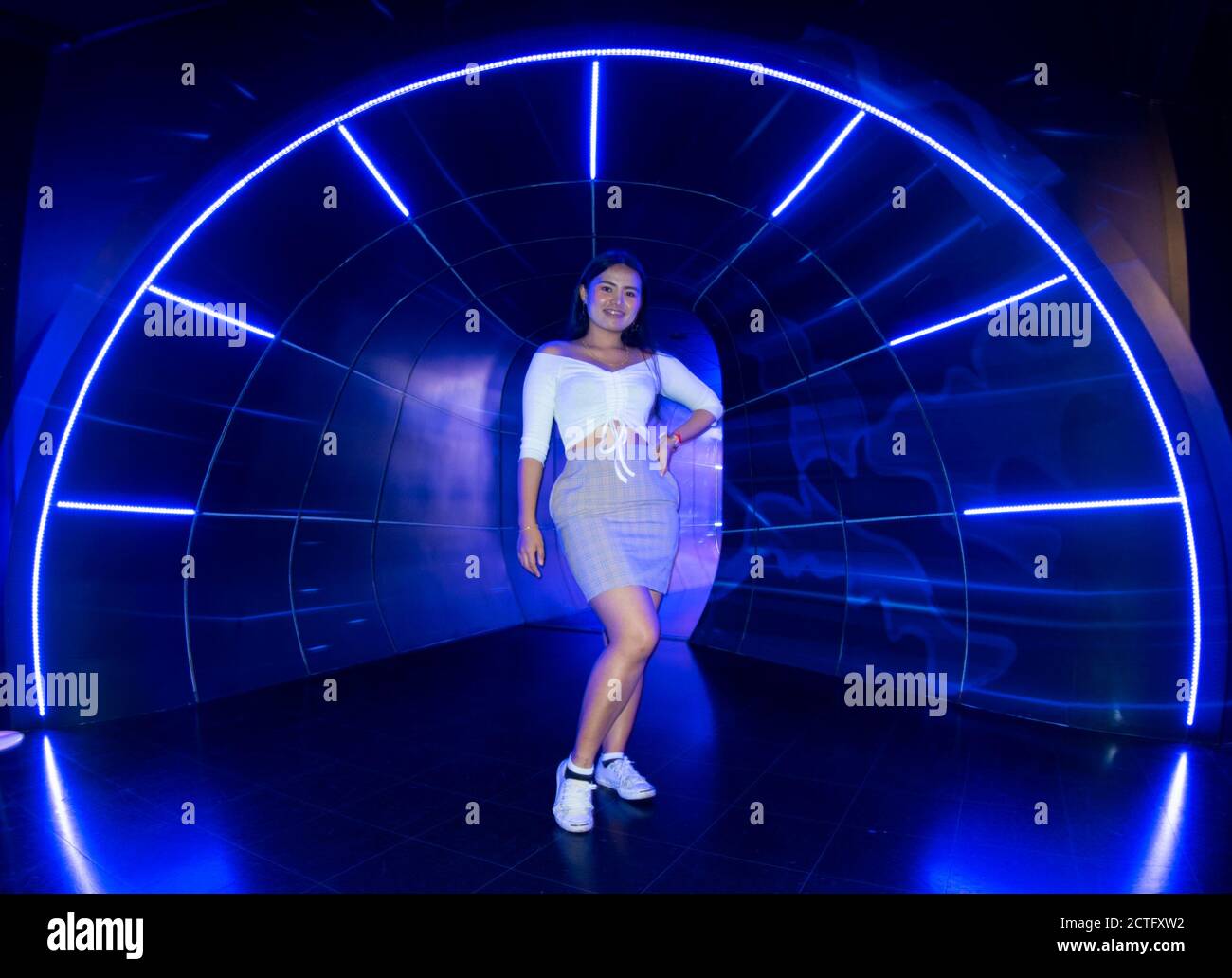 Bella ragazza in Blue neon tunnel luce Foto Stock