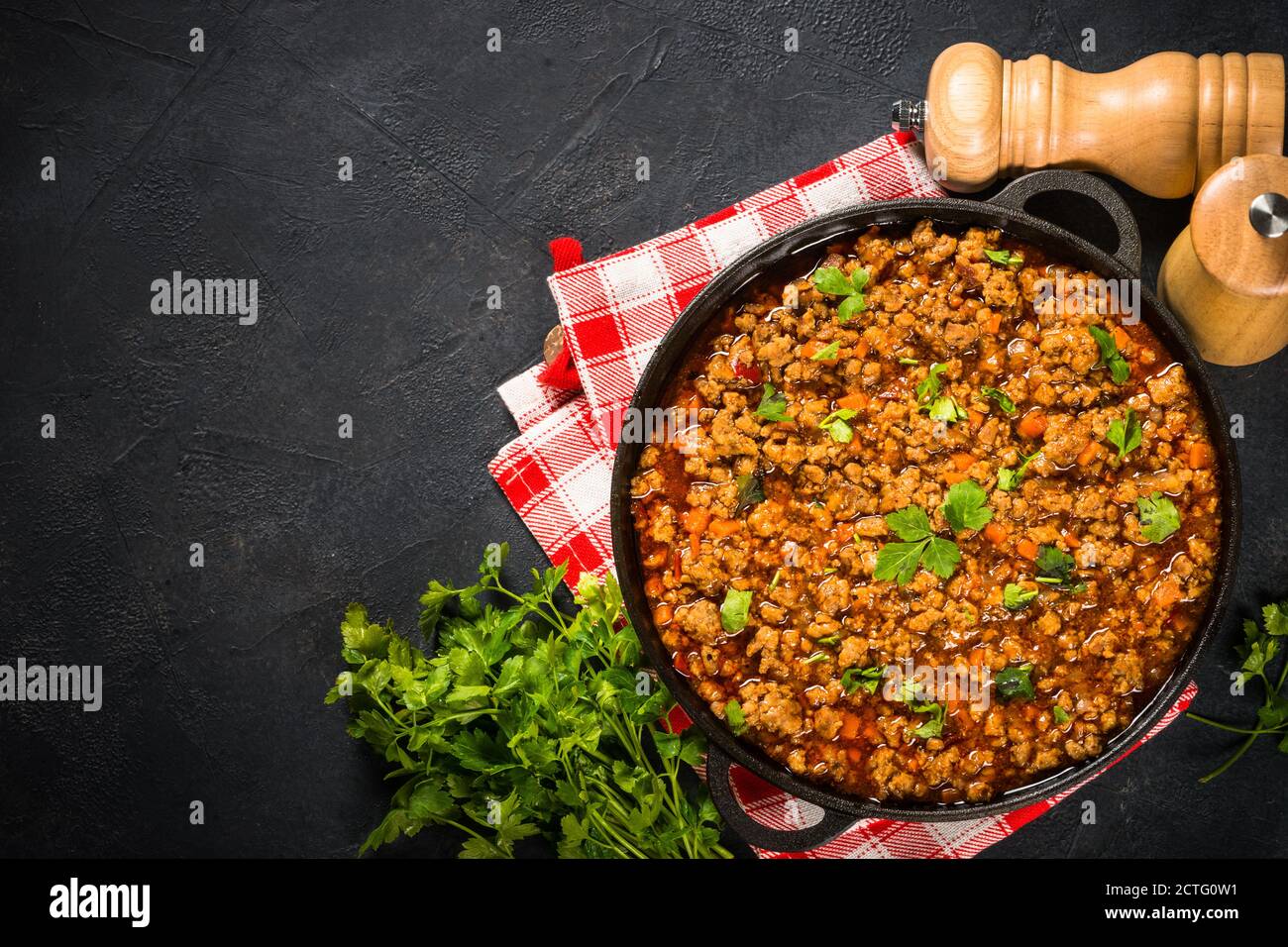 sause bolognese in piastra di ferro a tavola nera. Foto Stock