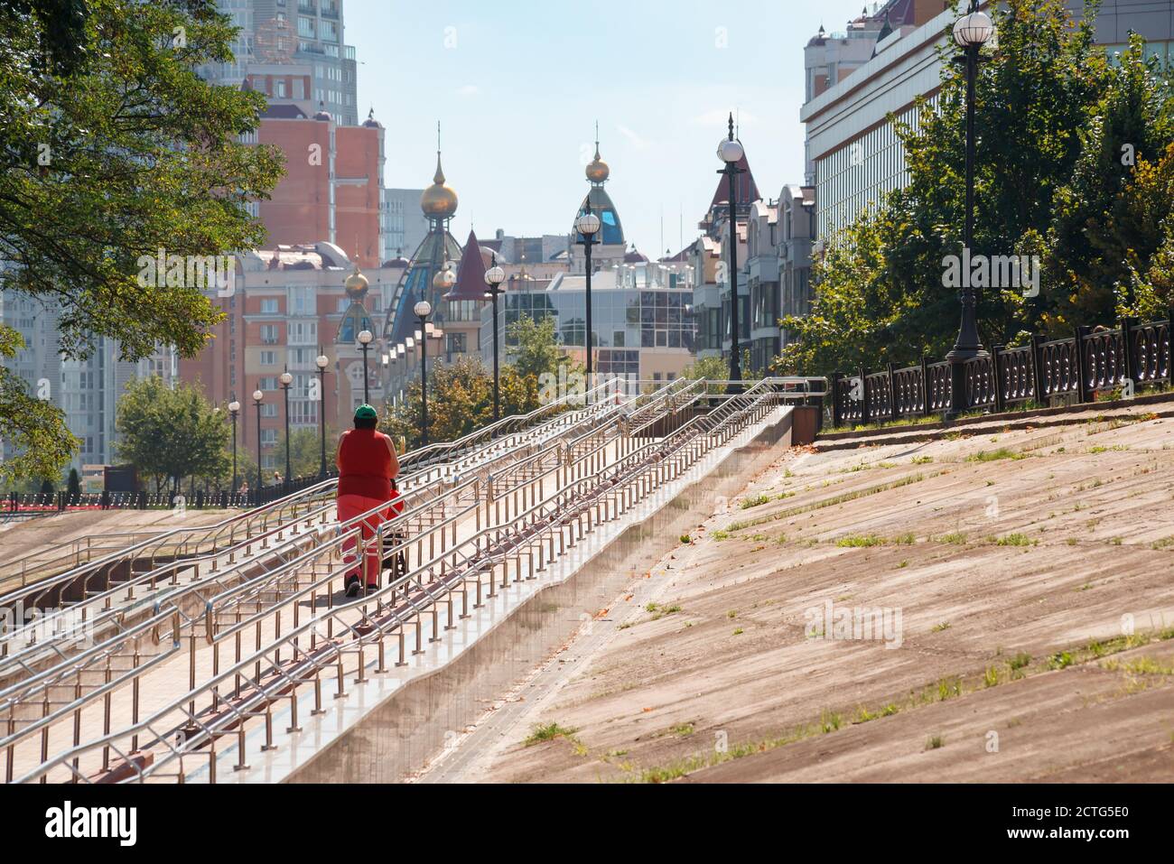 Kiev / Ucraina - 10 settembre 2020 - UNA donna sale una lunga rampa di metallo per disabili, biciclette e persone con passeggini, vicino Natalka Park i. Foto Stock