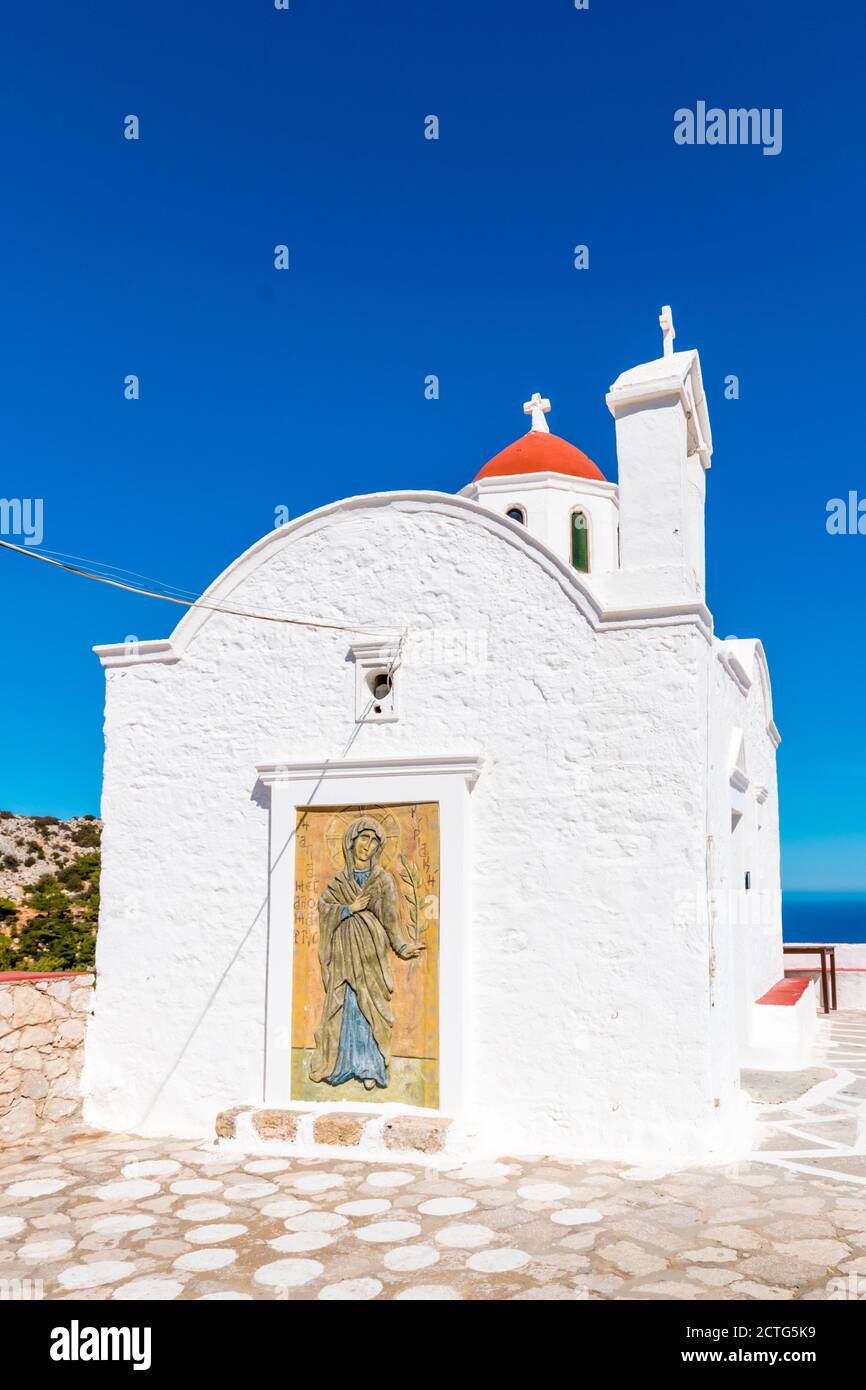 Cappella bianca di Agia Kyriaki con piccola cupola rossa, sulla cima di una scogliera, vicino a Pigadia, isola di Karpathos, Grecia Foto Stock