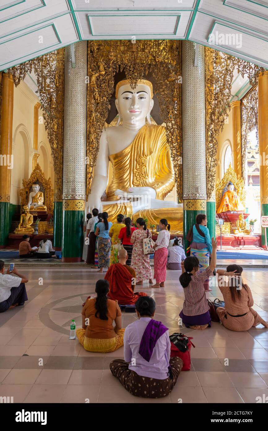 Persone che pregano Buddha nella pagoda di Shwedagon a Yangon, Birmania, Myanmar Foto Stock
