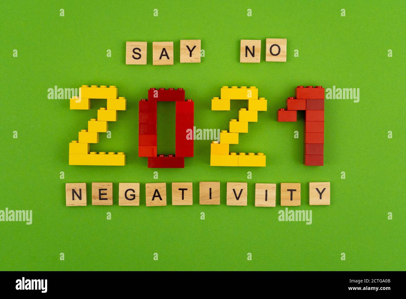 La frase dice no negativity 2021 è fiancheggiata da lettere di legno su uno sfondo verde. Figure dalla vista dall'alto del costruttore. Cartolina in posizione per Foto Stock