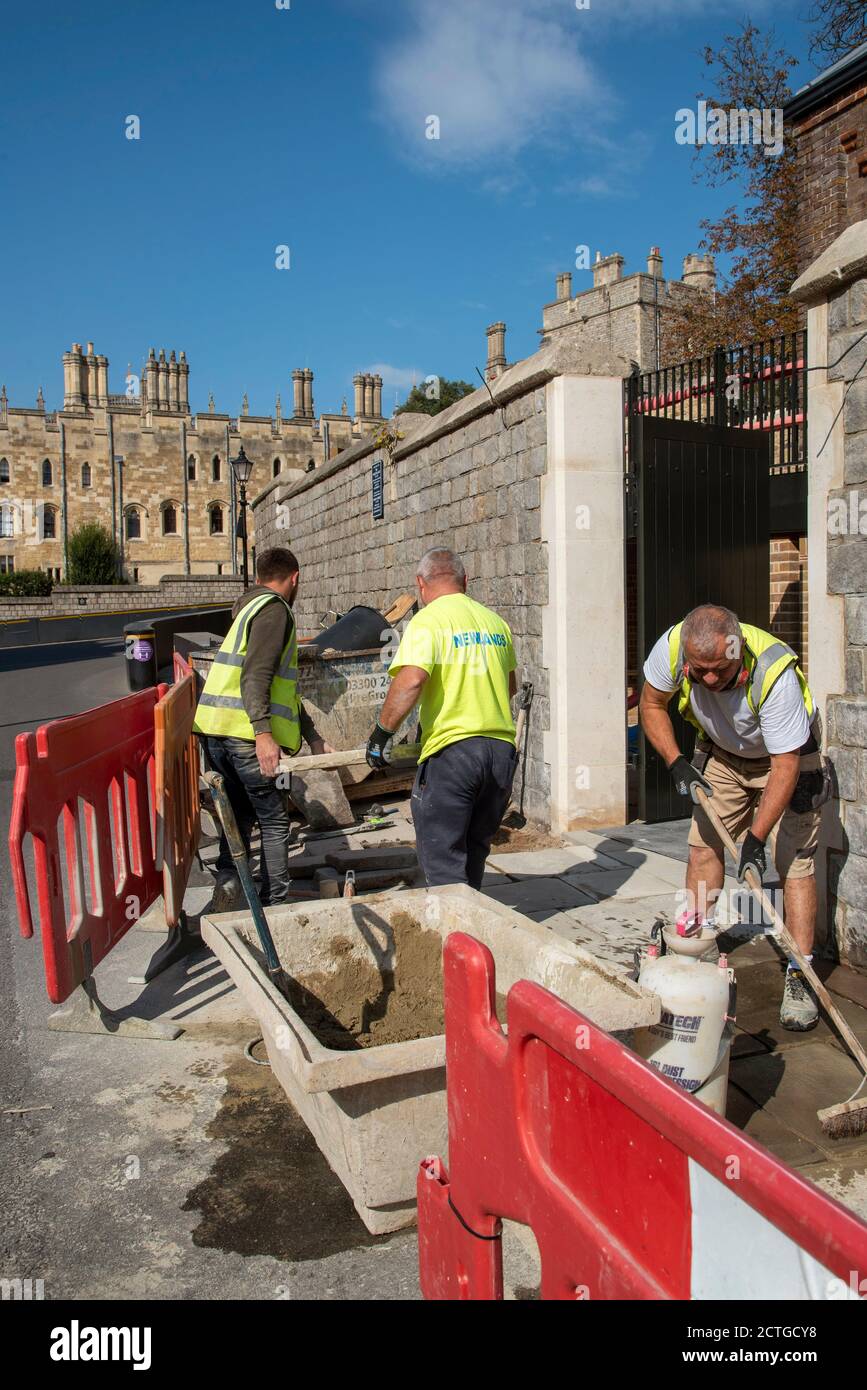 Windsor, Berkshire, Inghilterra, Regno Unito. 2020. Operai che posano lastre di pavimentazione sullo sfondo del Castello di Windsor. Foto Stock