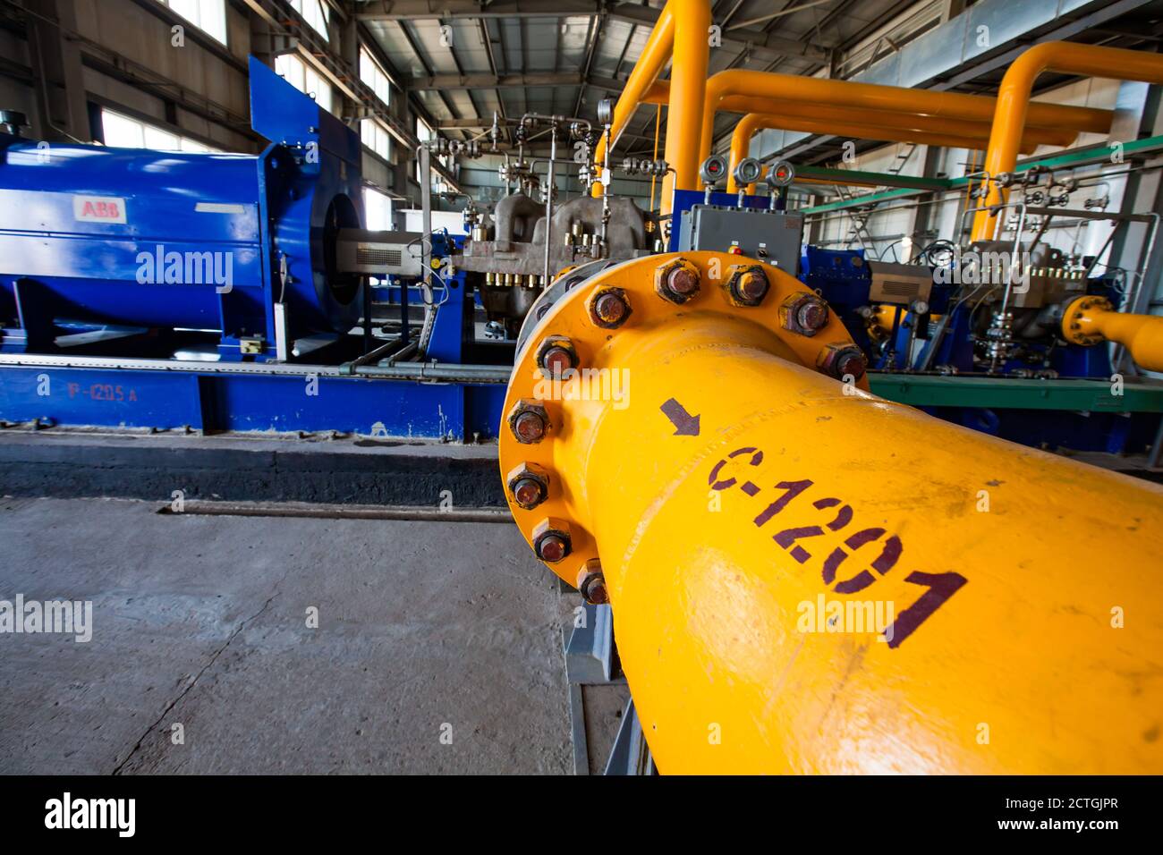 Regione di Aktobe/Kazakhstan - Maggio 04 2012: Stabilimento di raffineria di petrolio. Centrale a gas. Tubo ad alta pressione del gas giallo e generatore elettrico ABB sullo sfondo Foto Stock