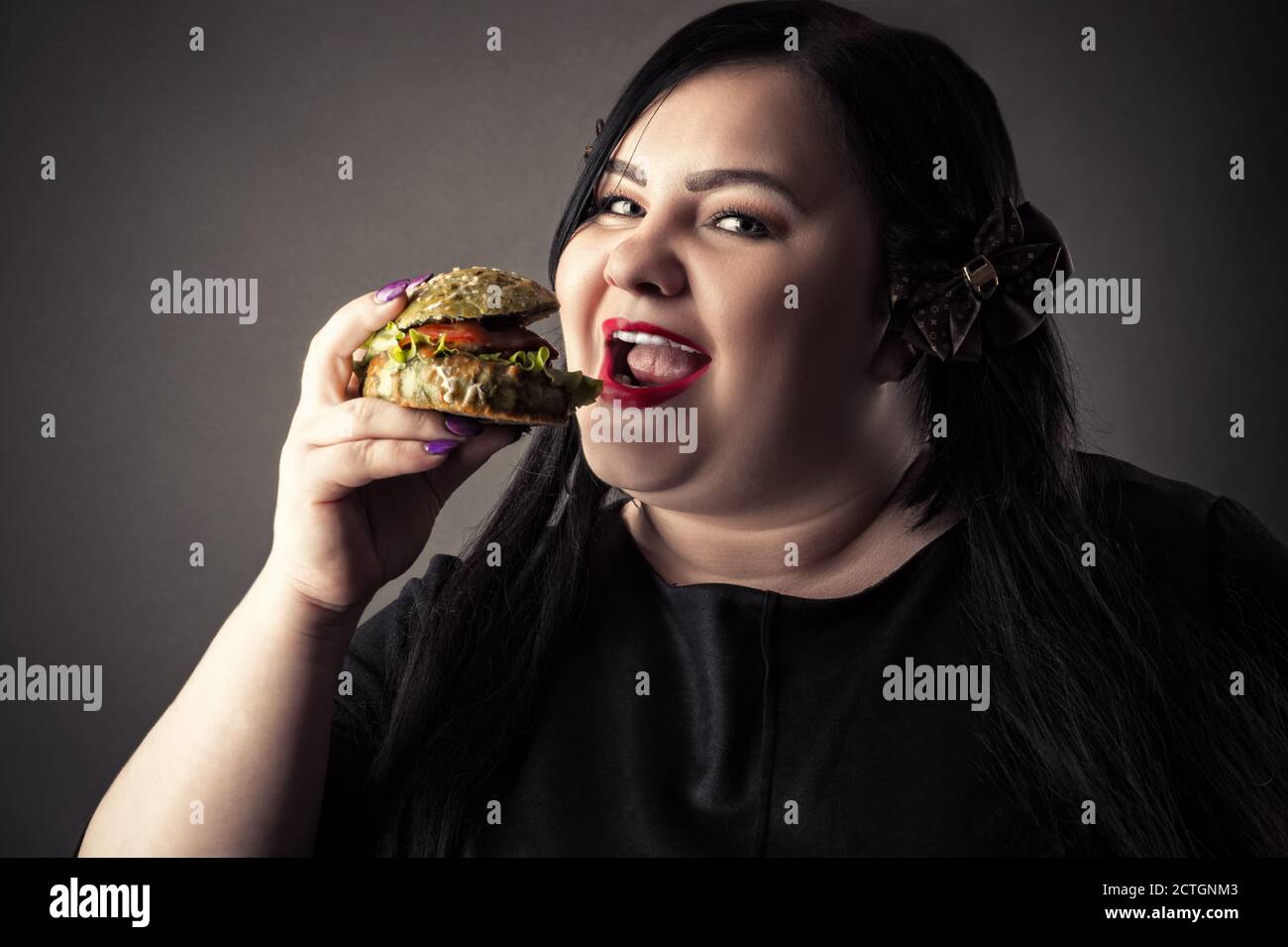 ritratto donna grasso mangiare hamburger Foto Stock