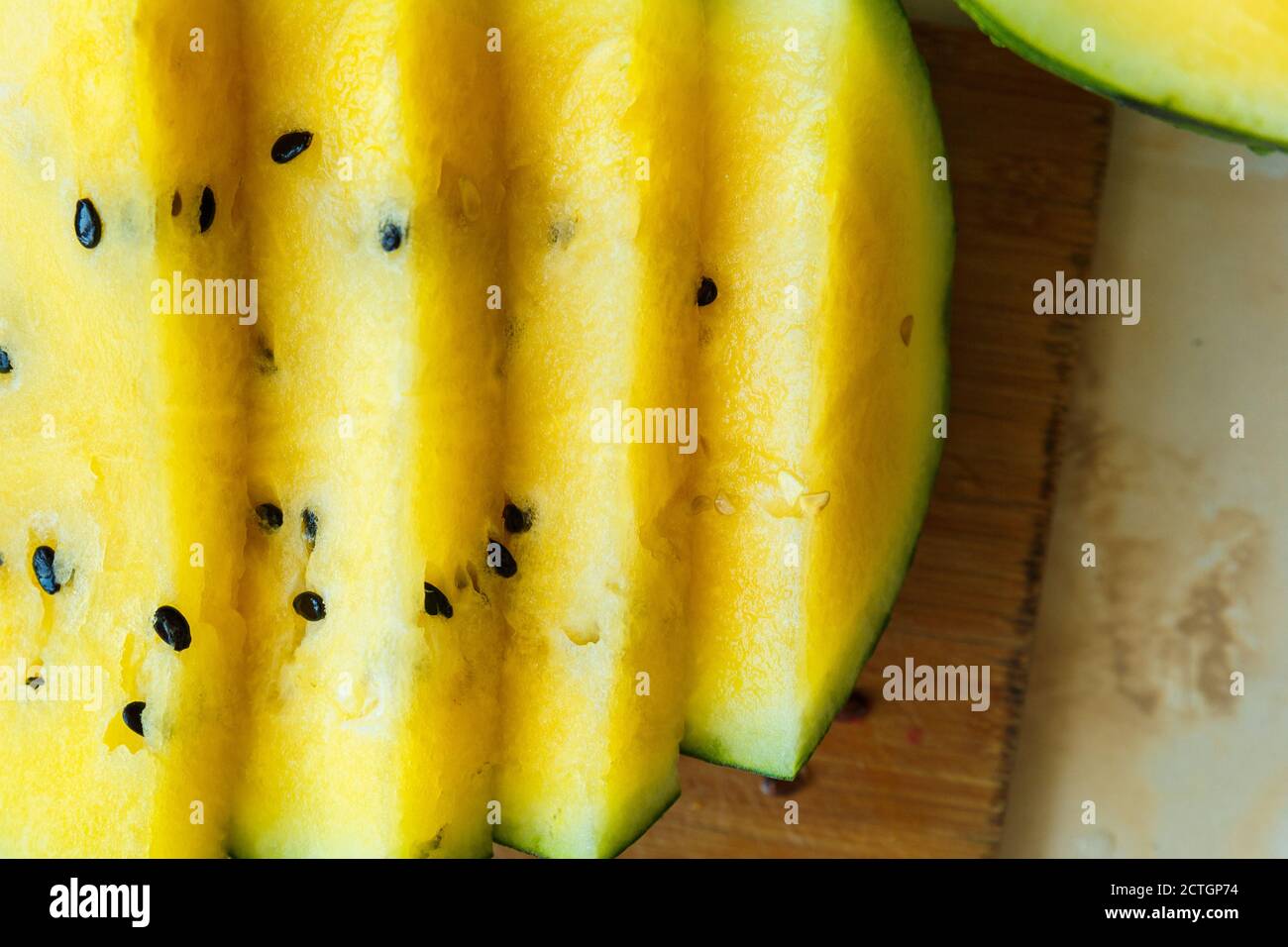 Cocomero con polpa gialla, tagliato a pezzi uguali e ben sistemato. Foto Stock
