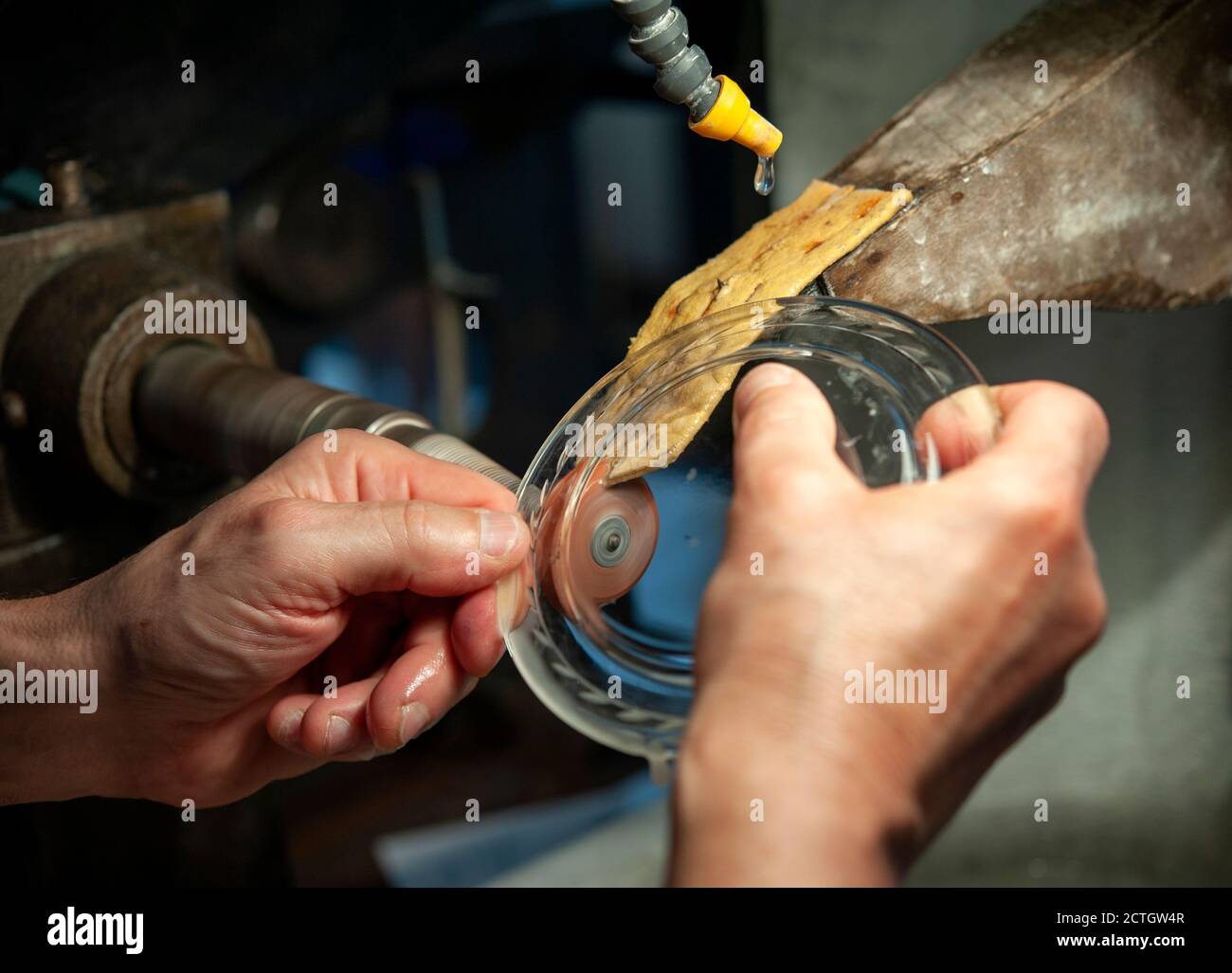 L'artigiano fa piccole incisioni su un piatto. Tecnica tradizionale di macinazione del vetro . Foto Stock