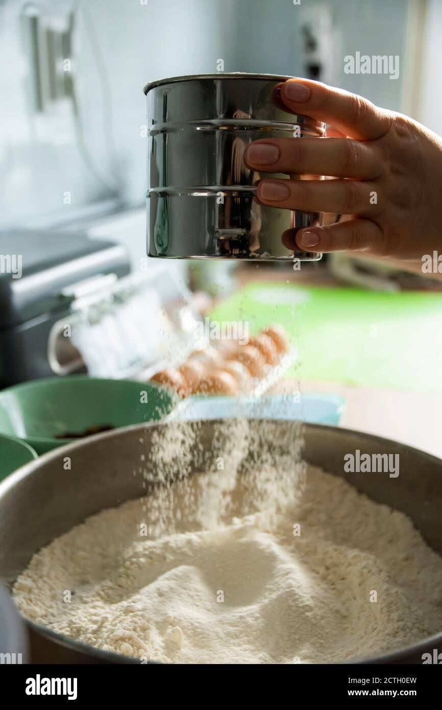 Persona setacciare la farina con un filtro di farina Foto Stock