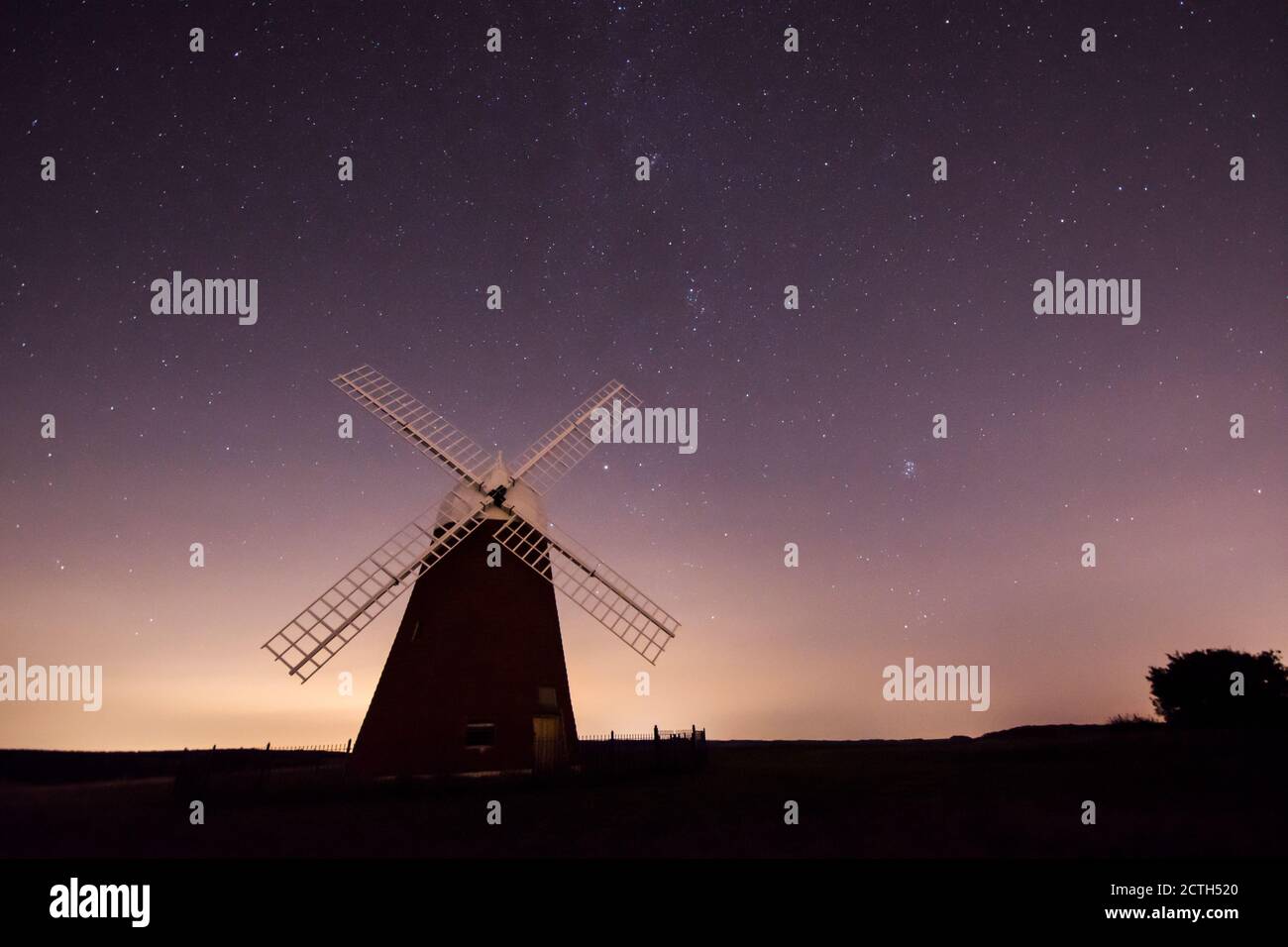 Il mulino a vento di Halnaker si presenta con le sue silhouette contro il cielo notturno pieno di stelle, Faint Milky Way, rinnovato con vele, Sussex, UK, Foto Stock