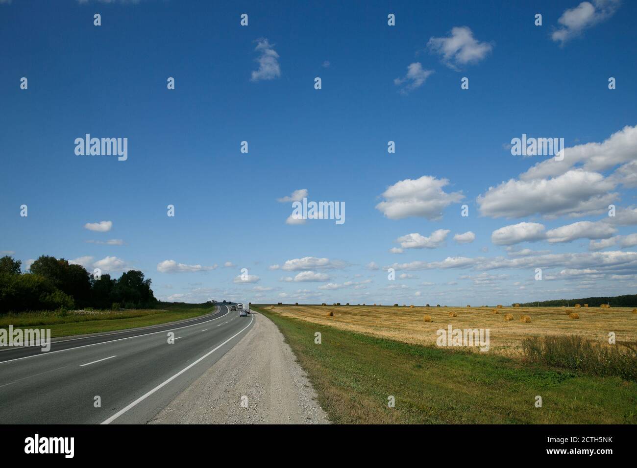 Percorso Intercity passando campi e foreste in una giornata estiva con cielo nuvoloso Foto Stock