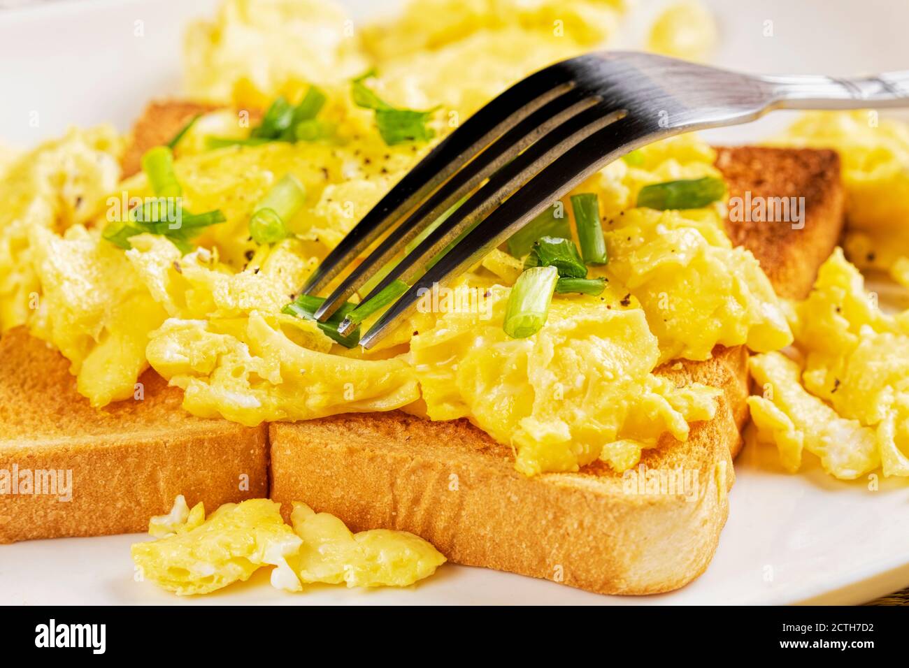 Una deliziosa colazione a base di uova strapazzate e pane tostato con copia spazio Foto Stock