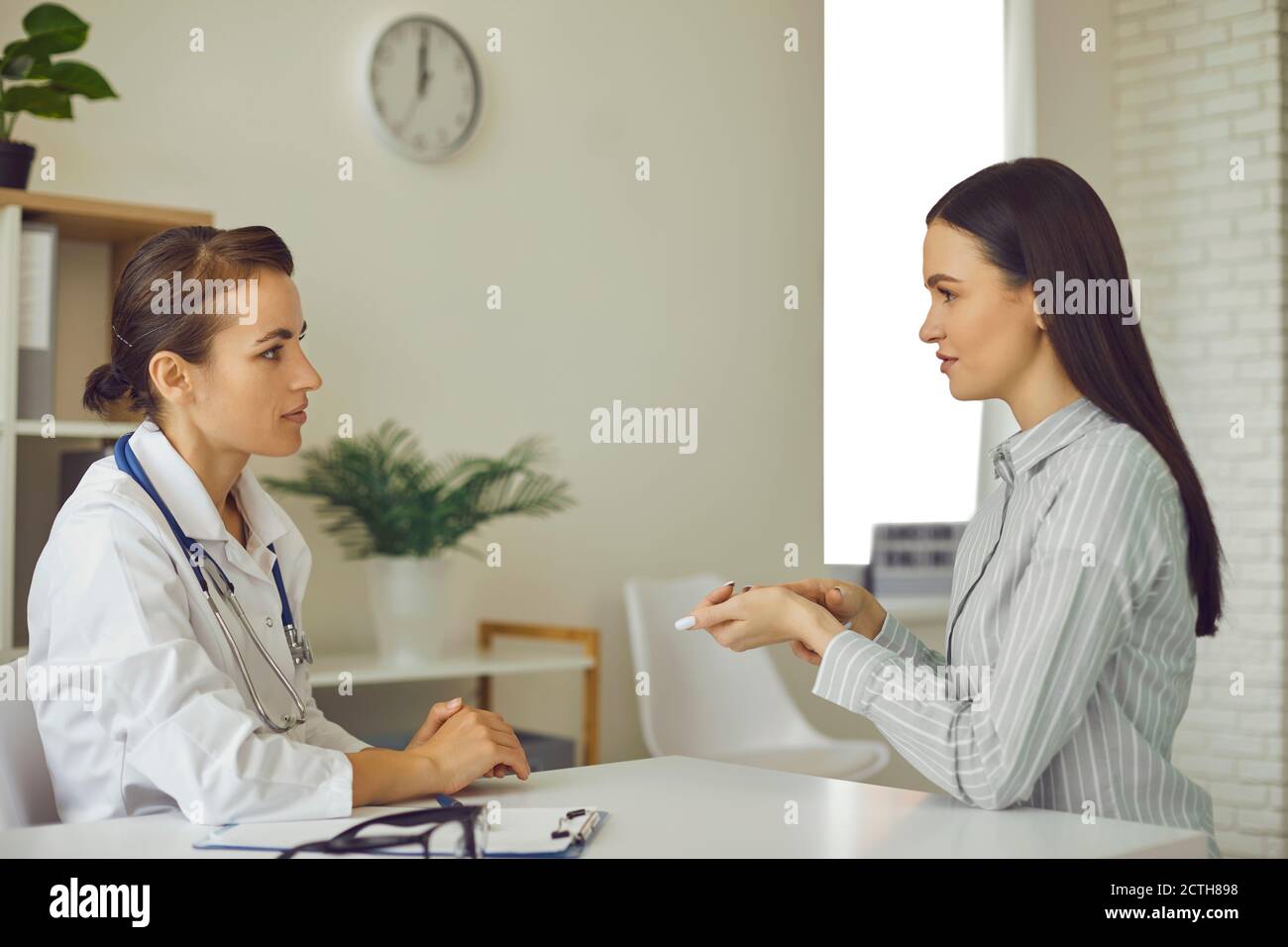 Giovane paziente che dice al medico i suoi problemi di salute, descrivendo i sintomi e chiedendo consiglio Foto Stock