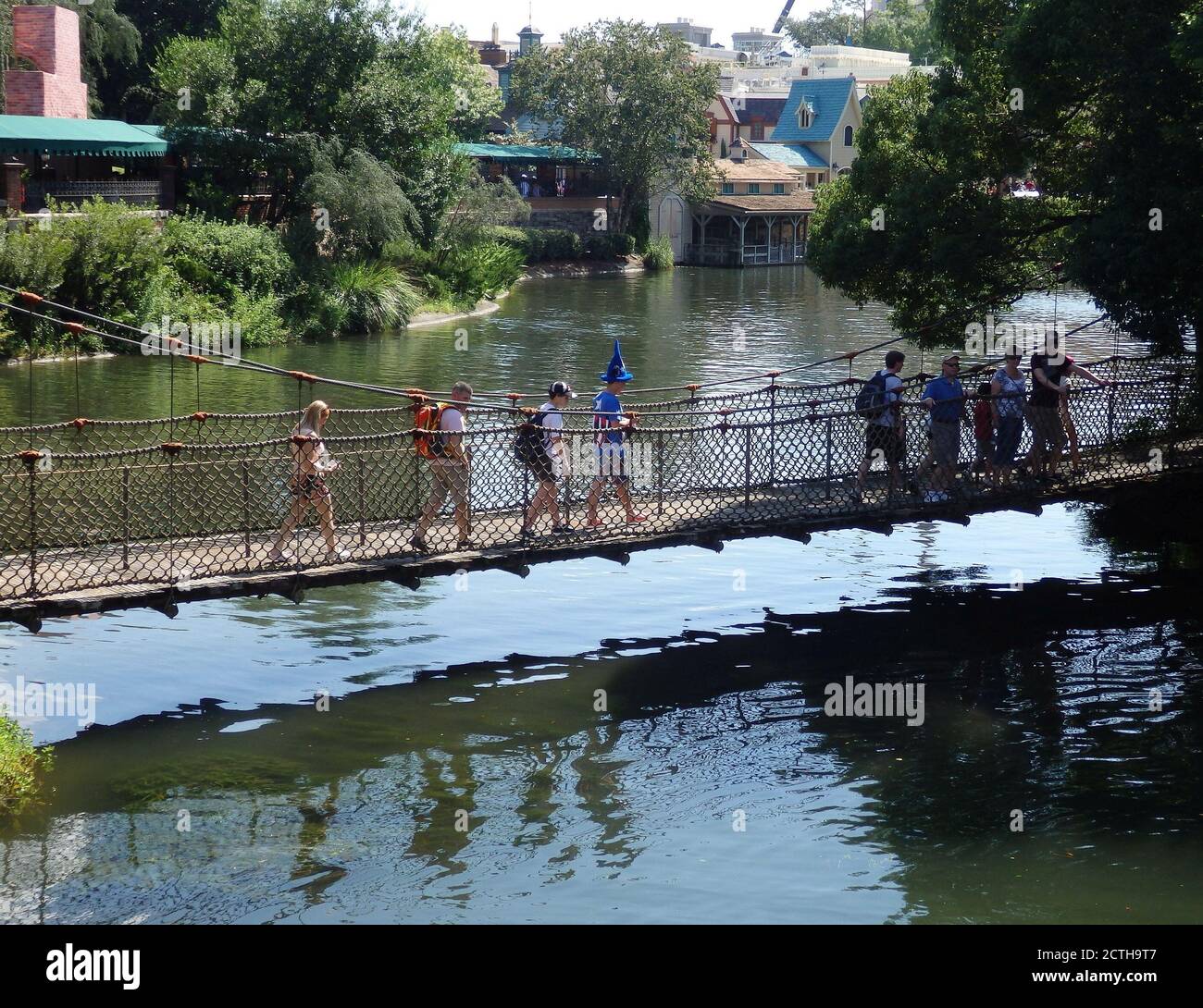 Persone che attraversano un fiume camminando su un ponte di corda di legno nel Walt Disney World, Orlando Florida, Stati Uniti Foto Stock