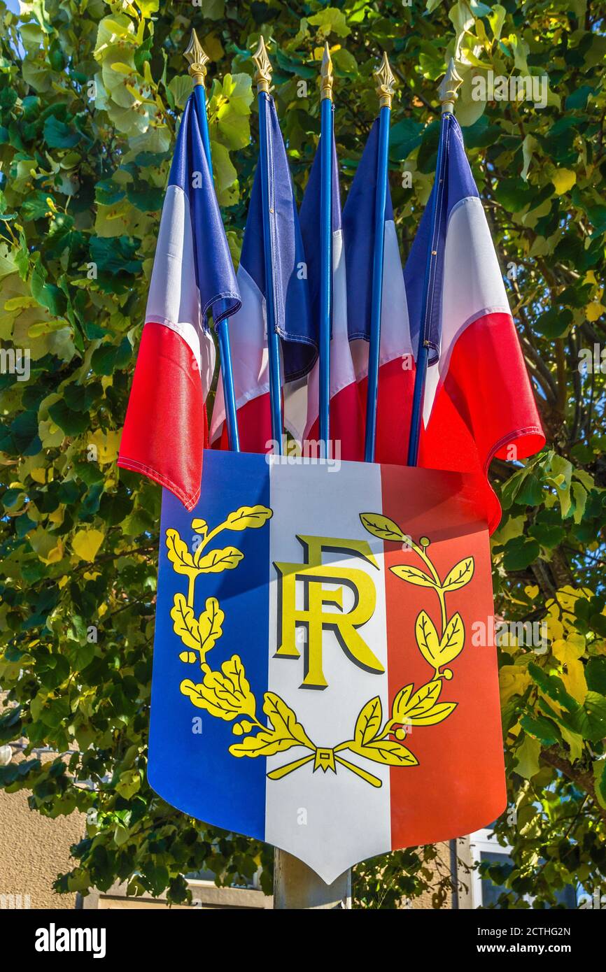 Bandiere tricolore e scudo di stato francesi - Oradour-Saint-Genest, Haute-Vienne (87), Francia. Foto Stock