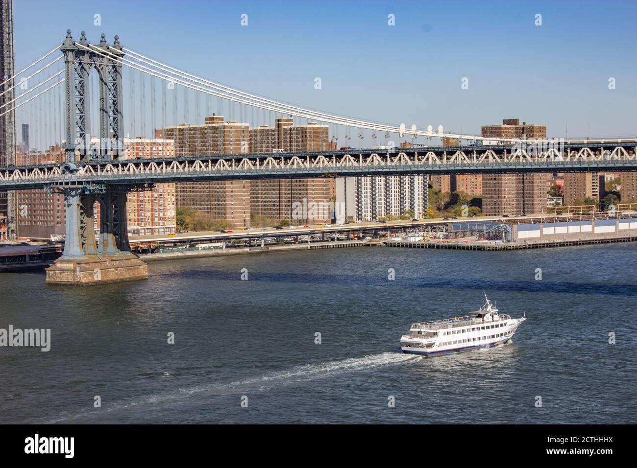 Barca sul Fiume Est passando sotto il Ponte di Manhattan Foto Stock