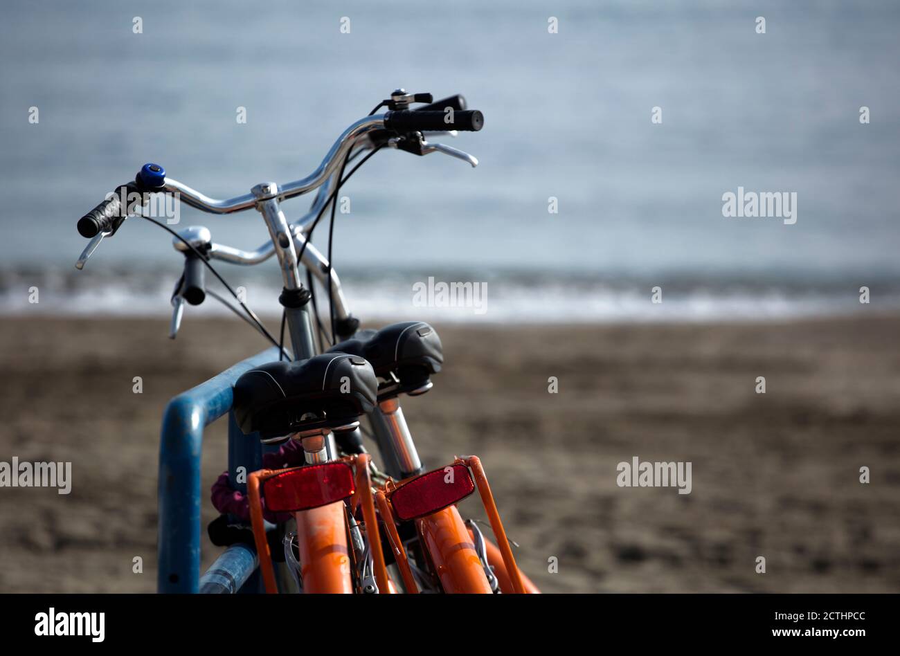 concetto di mobilità ecologica, due classiche biciclette rosa, parcheggiate in riva al mare, Foto Stock