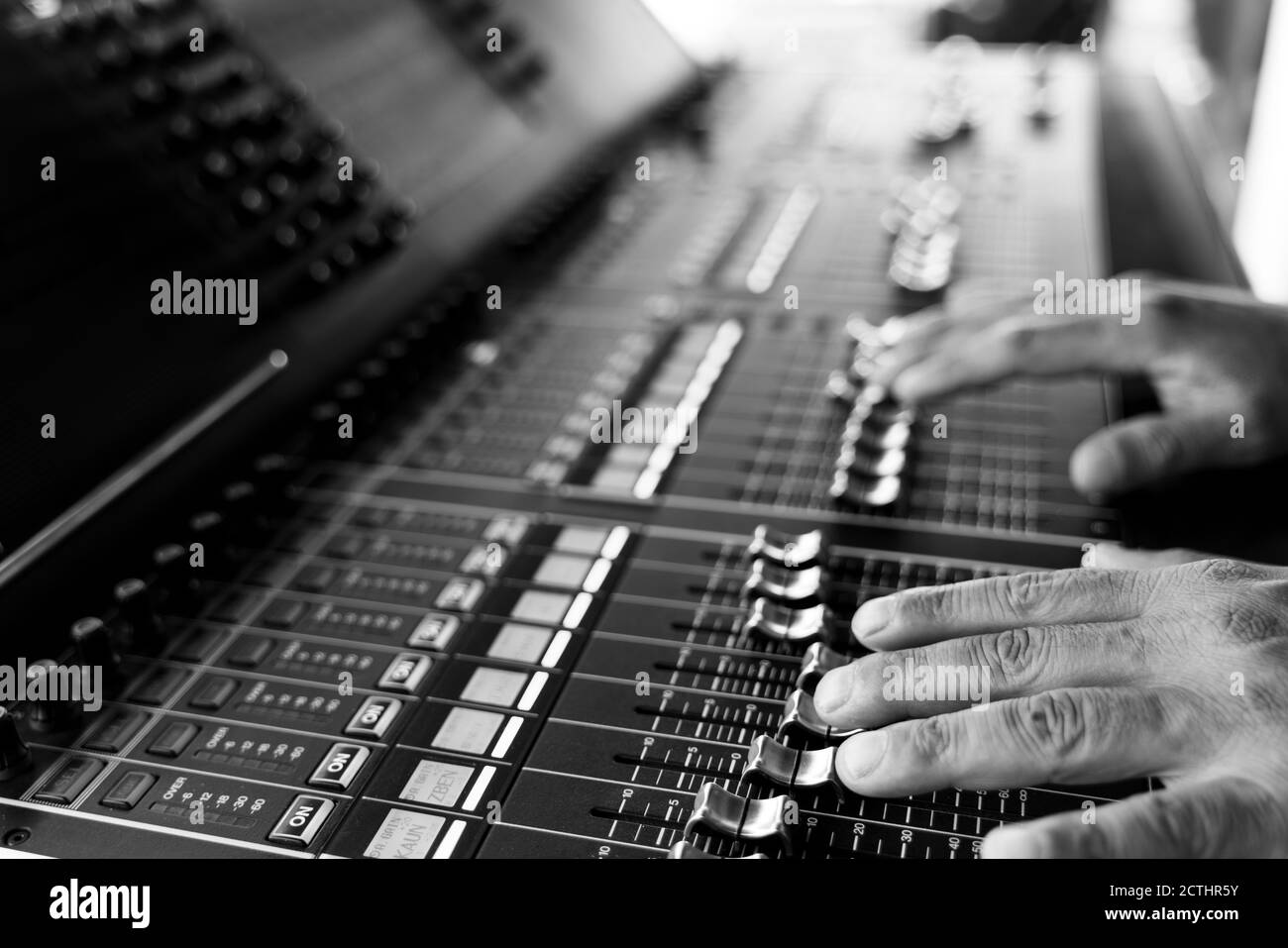 Il tecnico del suono lavora con le mani sul mixer del suono in concerto dal vivo. Immagine in bianco e nero Foto Stock