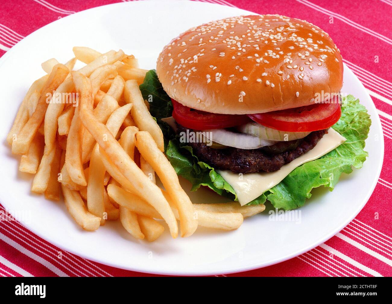 Burger e patatine fritte in plat su tovaglia. Ketchup e bottiglia di senape sullo sfondo. Primo piano fotografia professionale per hotel, menu ristorante Foto Stock