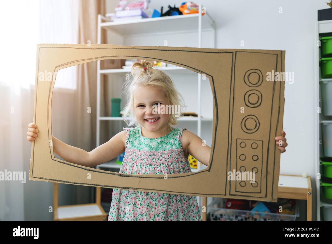 bambino allegro che gioca con la tv di cartone a casa. concetto di professione di sogno futuro Foto Stock