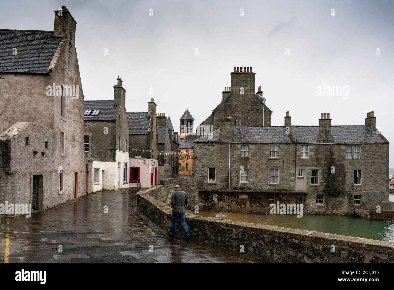 Uomo che cammina su Commercial Street nel centro storico di Lerwick, Shetland, Scozia, Regno Unito Foto Stock