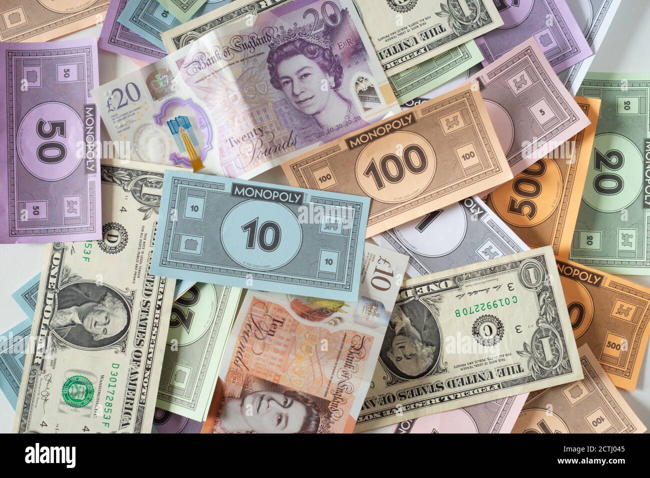 Banconote in mezzo a monopoli, una metafora per l'inflazione, debito, valore in diminuzione, tassi di interesse, mancanza di potere d'acquisto, valuta debole Foto Stock