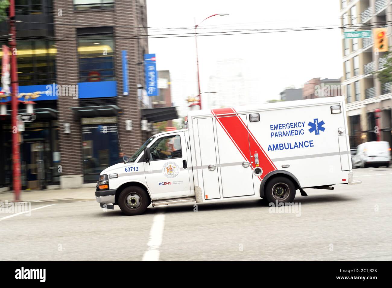 Un'ambulanza paramedica di emergenza si precipita in una scena di incidente lungo Main Street a Vancouver, British Columbia, Canada Foto Stock