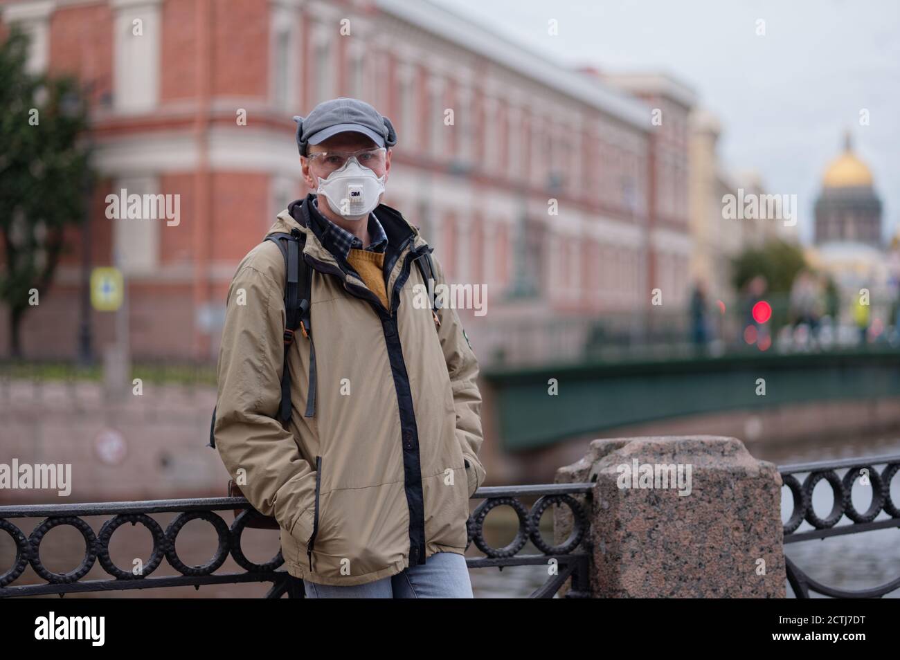 Uomo maturo con respiratore nel centro di San Pietroburgo. Nuova normalità durante la pandemia COVID-19 Foto Stock