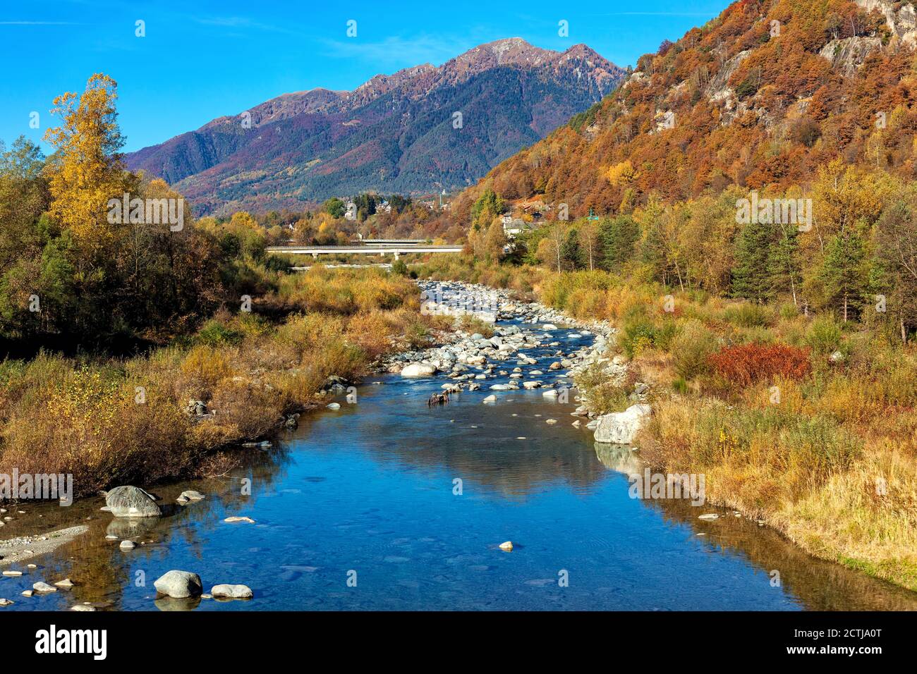 Vista sulle rocce del piccolo fiume alpino tra le colorate montagne autunnali della Svizzera. Foto Stock