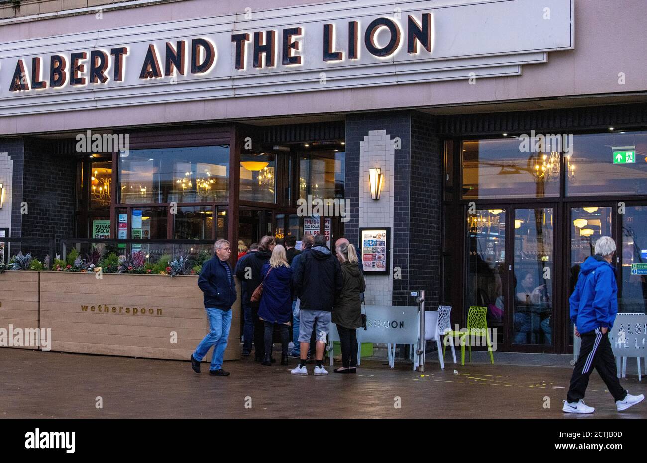 La gente accatastava fuori da un pub Wetherspoons a Blackpool. Tutti i pub, i bar e i ristoranti in Inghilterra devono avere un orario di chiusura delle 22:00 da giovedì, per contribuire a frenare la diffusione del coronavirus. Foto Stock