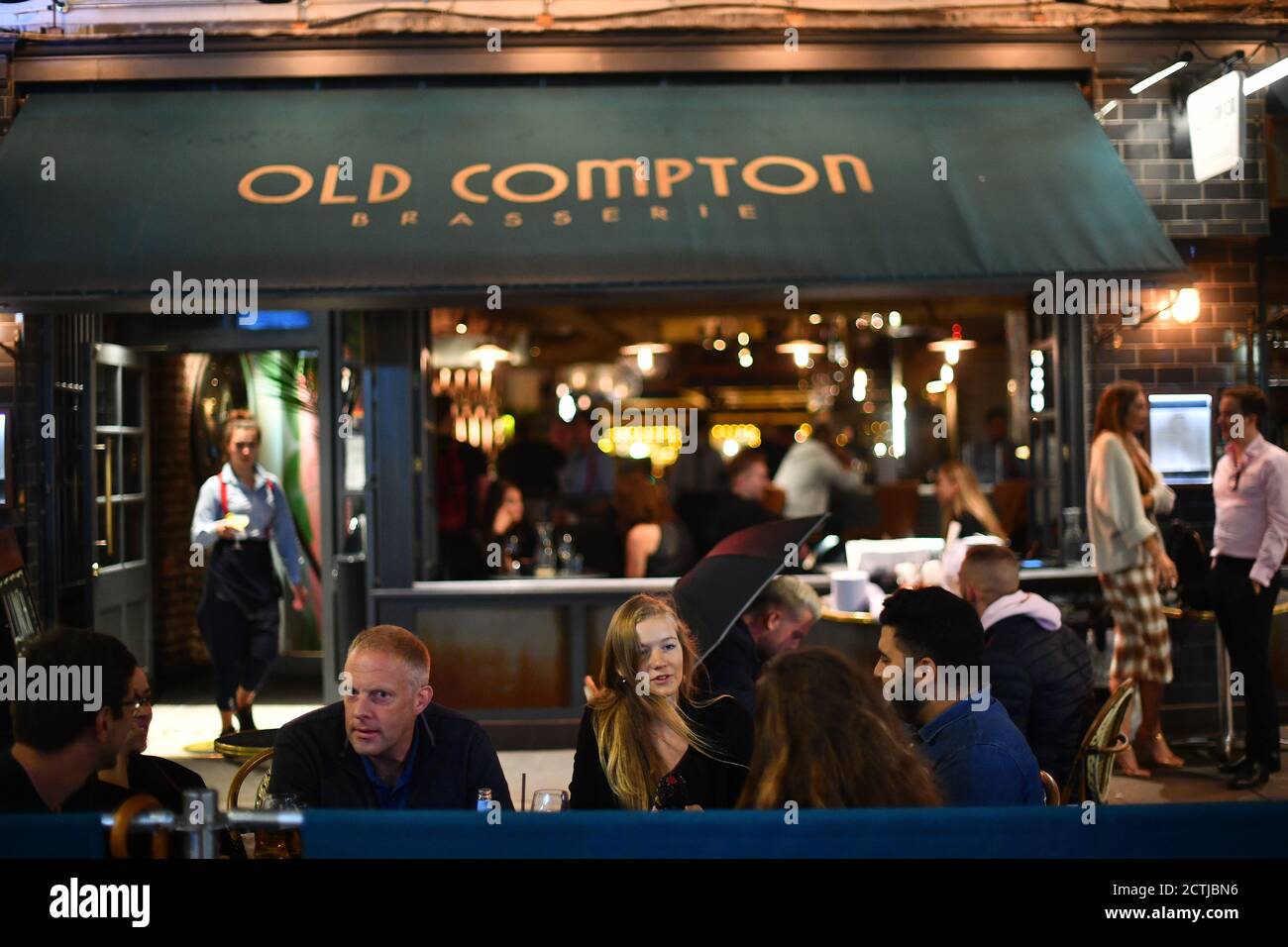 Persone che bevono fuori dall'Old Compton a Soho, Londra. Tutti i pub, i bar e i ristoranti in Inghilterra devono avere un orario di chiusura delle 22:00 da giovedì, per contribuire a frenare la diffusione del coronavirus. Foto Stock