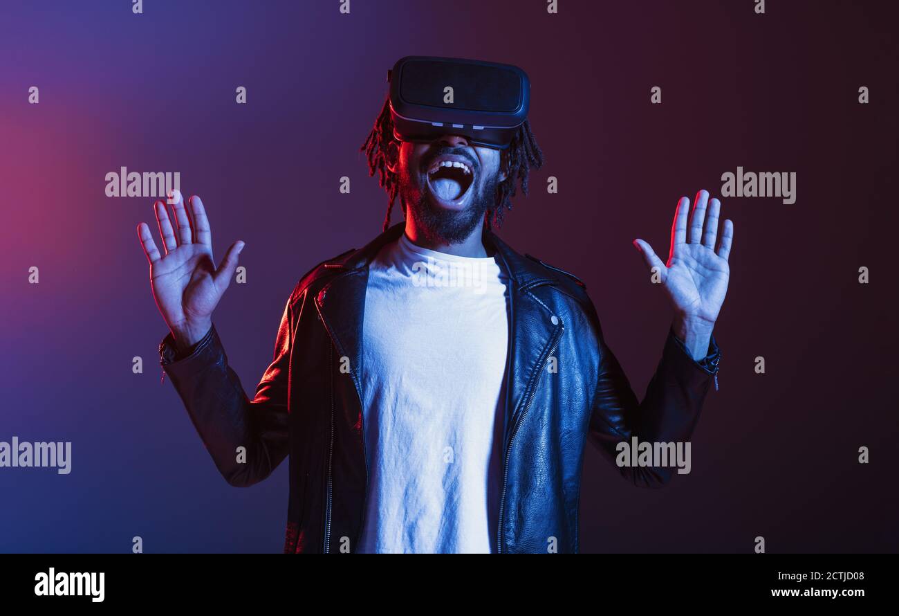 Un uomo con occhiali VR gioca con un videogioco virtuale Foto Stock