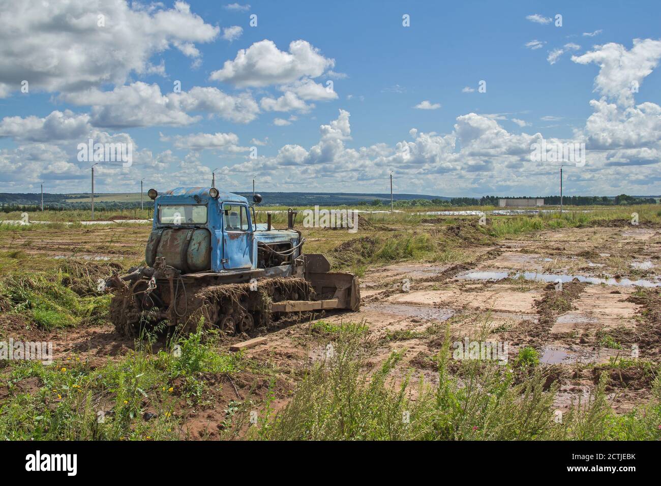 Un vecchio trattore cingolato sullo sfondo del paesaggio. Macchine agricole sul campo Foto Stock