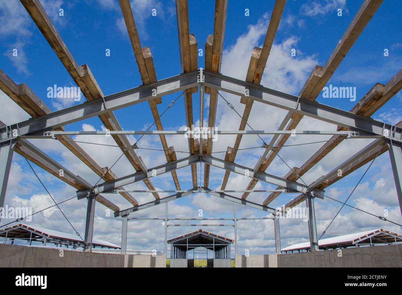 Il design del tetto. Travi in legno su telaio in acciaio. Telaio in acciaio di un edificio in costruzione. Foto Stock