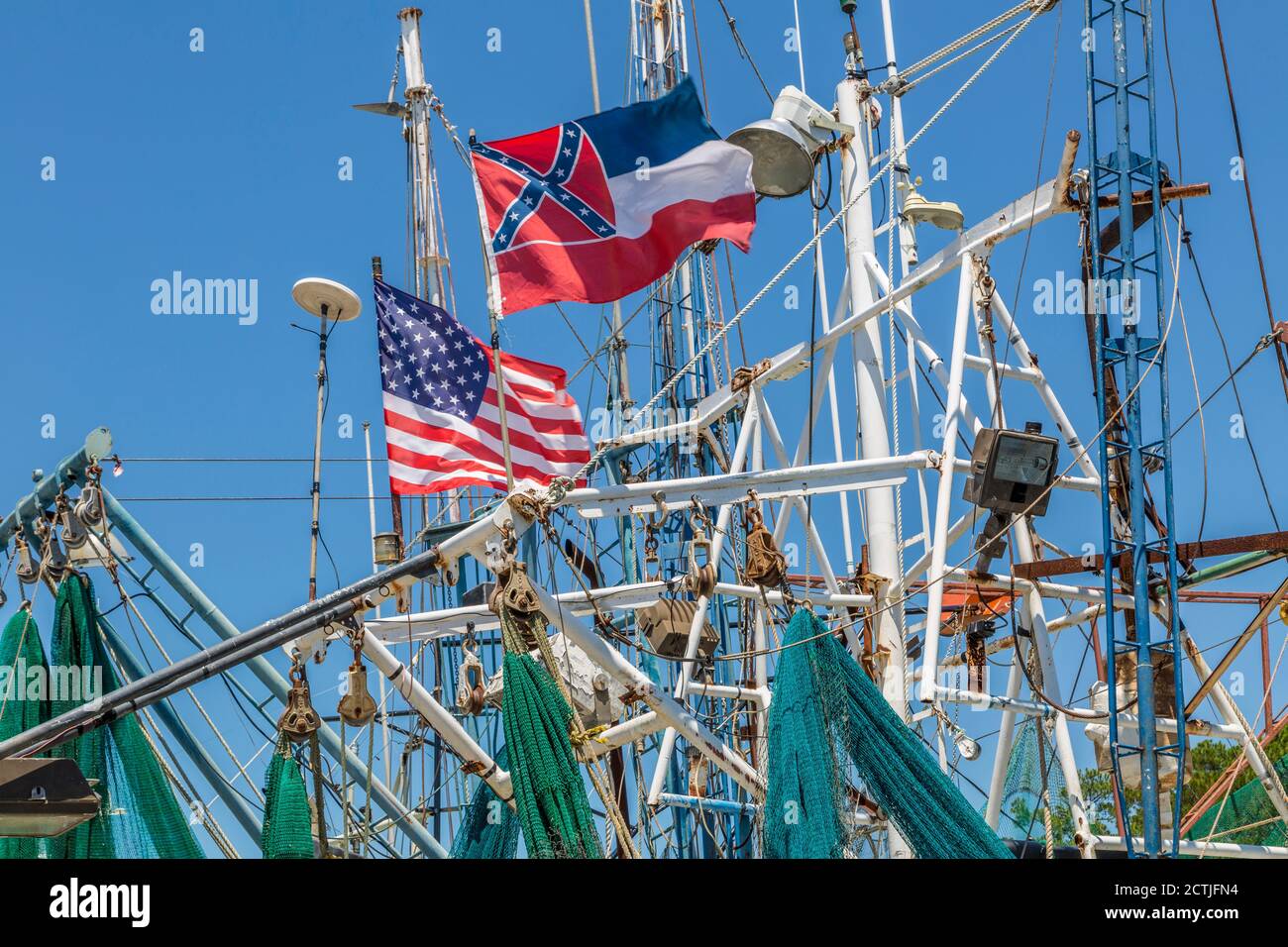 Bandiera dello stato del Mississippi e bandiera degli Stati Uniti che sorvolano le imbarcazioni Shrimp al molo del porto interno di Ocean Springs, Mississippi Foto Stock