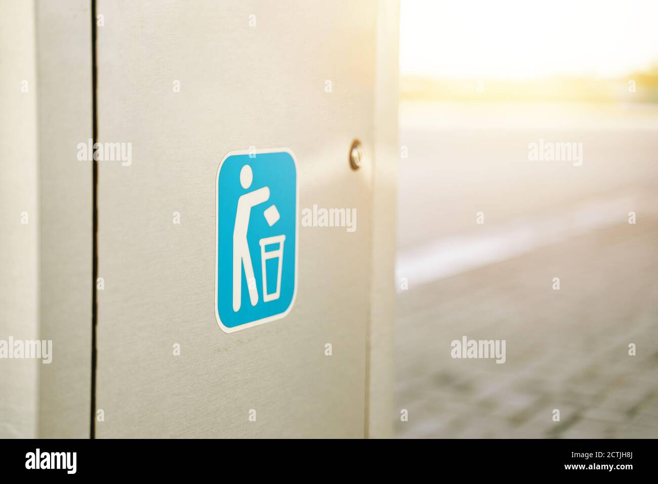 Logo su un moderno serbatoio di rifiuti sulla strada. Sportello in metallo. Logotipo con la figura di un uomo gettando spazzatura nel cestino. Foto Stock
