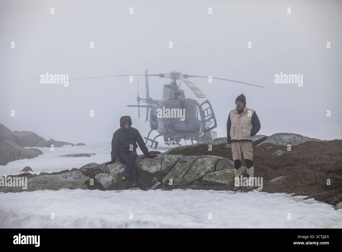 Il pilota dell'elicottero e il passeggero aspettano il miglioramento delle condizioni meteorologiche, in difficoltà. Foto Stock