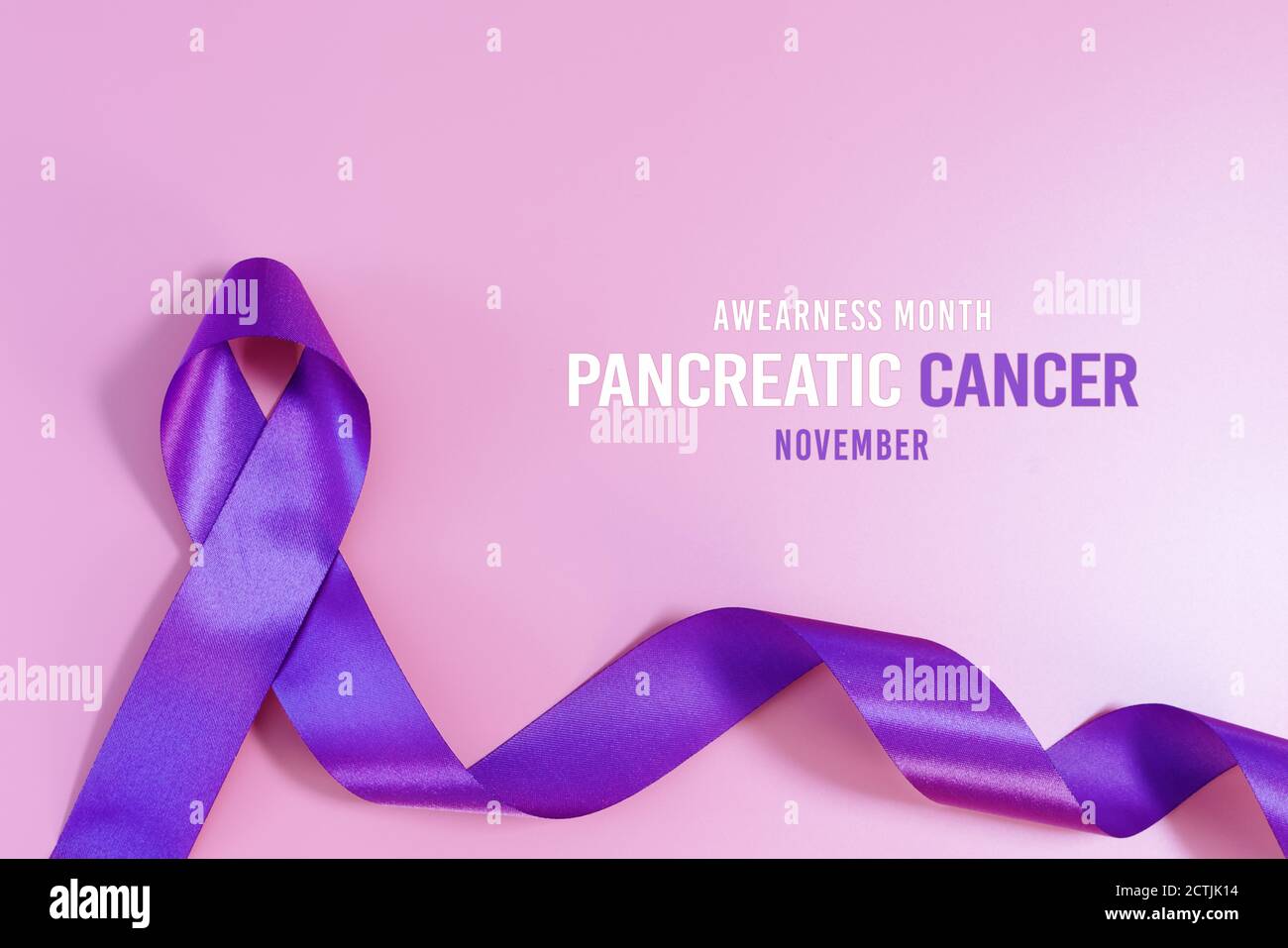 Il cancro pancreatico consapevolezza nastro, viola i nastri sulla luce sfondo rosa Foto Stock
