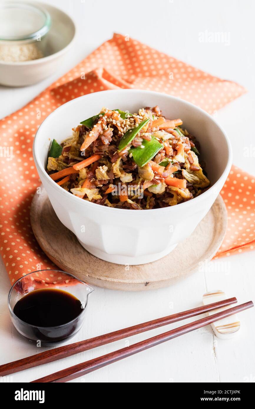 Bastoncini di pollo e ciotola di riso rosso fritto con verdure Foto Stock