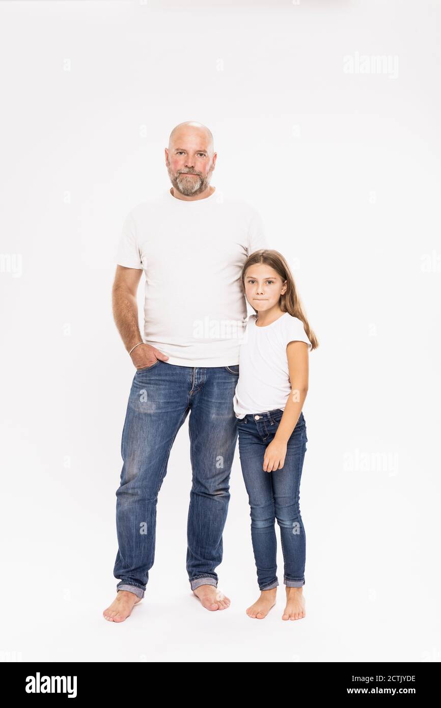 Padre calvo con figlia in piedi su sfondo bianco Foto Stock