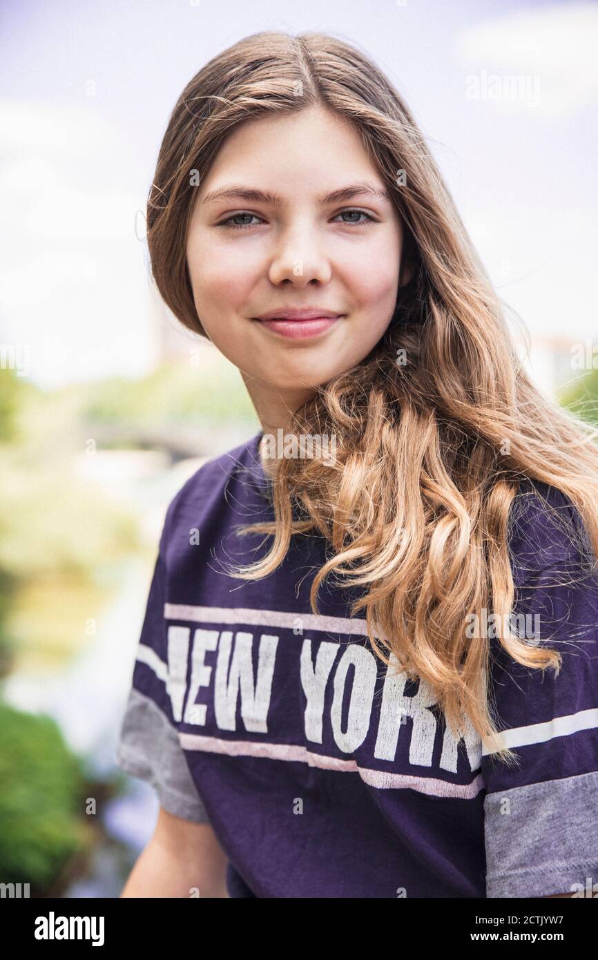 Ragazza sorridente con lunghi capelli biondi all'aperto Foto Stock