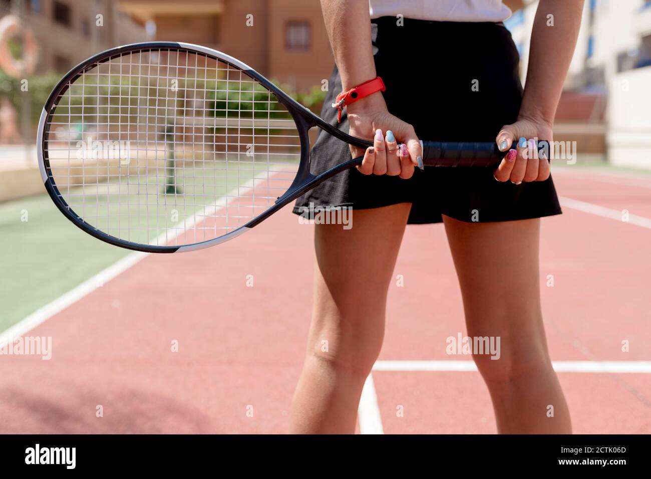 Primo piano di una tennista femminile con le mani dietro la schiena racchetta in campo Foto Stock
