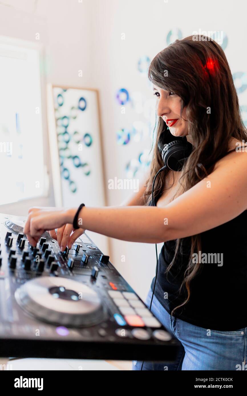 Bellissimo DJ club che utilizza attrezzature techno presso studio di registrazione Foto Stock