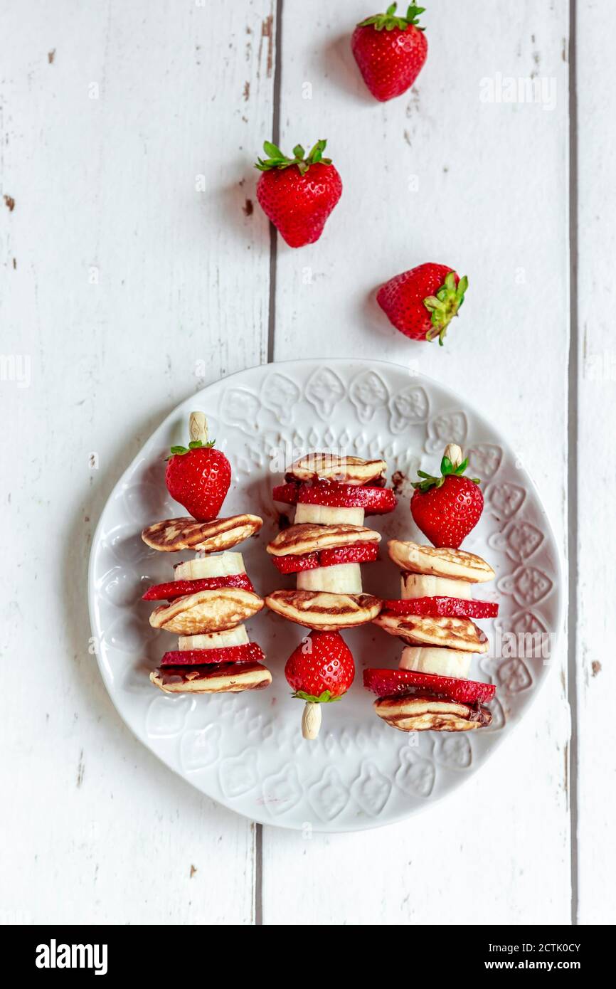 Piatto di mini frittelle con fragole e banane Foto Stock
