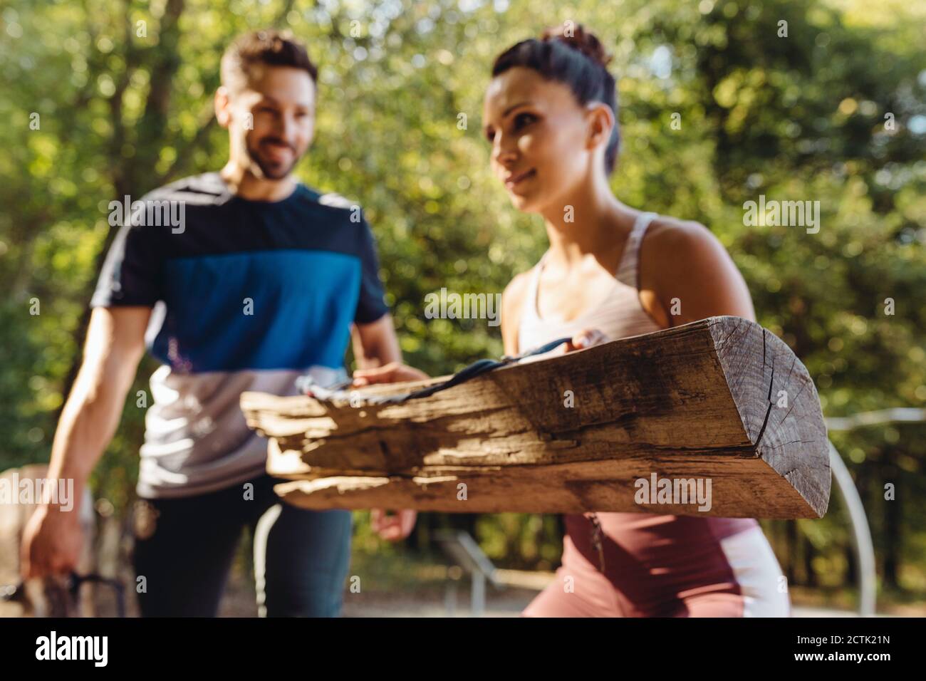 Donna e uomo che sollevano i tronchi pesanti su un fitness sentiero Foto Stock