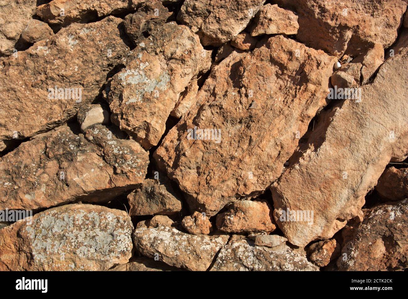 Struttura rocciosa di una parete senza Malta formata da irregolare pietre marrone chiaro Foto Stock