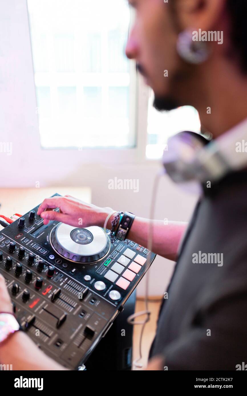 Giovane produttore di musica maschile mixando il suono in studio di registrazione Foto Stock