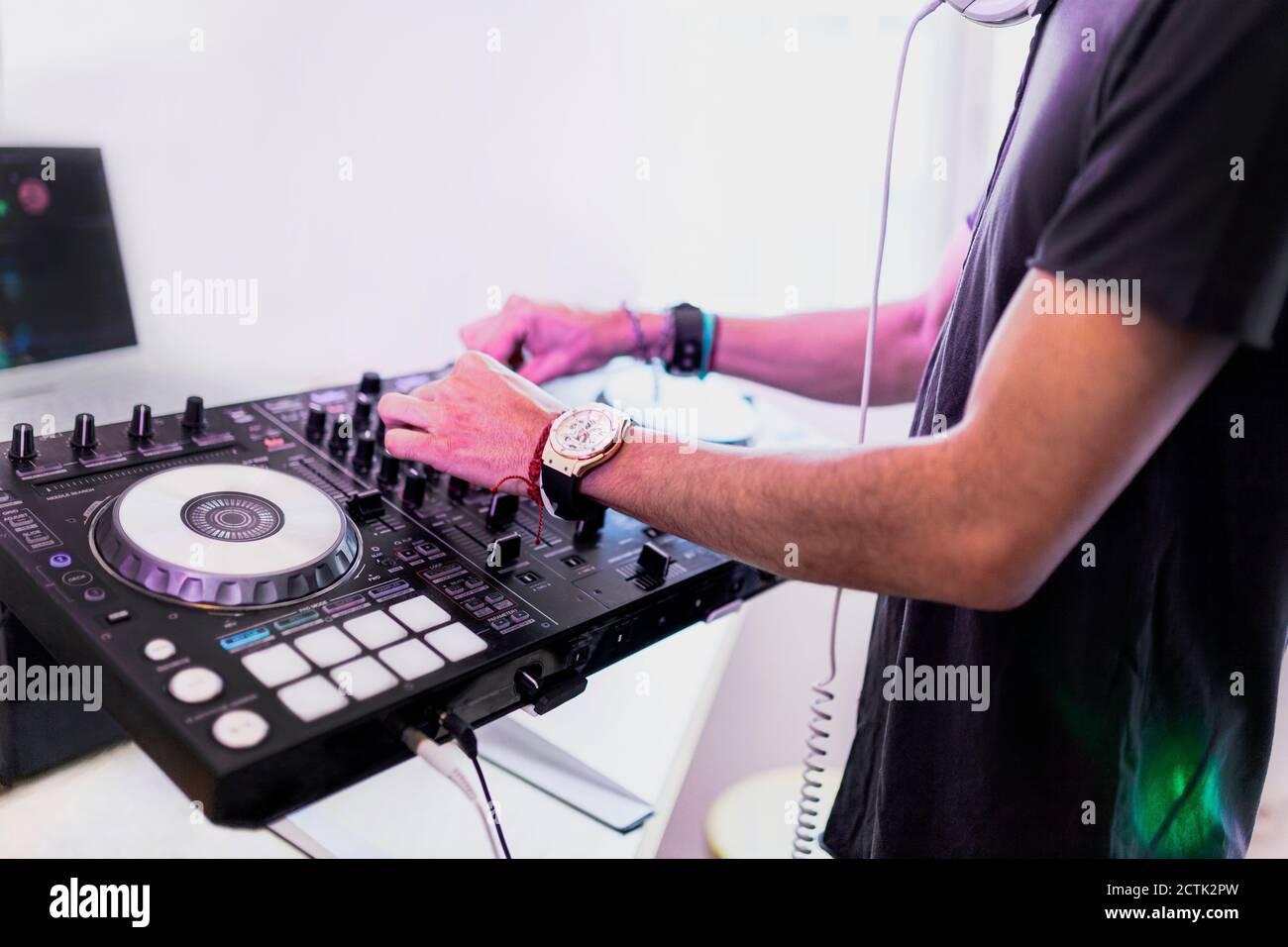 Giovane DJ maschile mixando suono in studio di registrazione Foto Stock